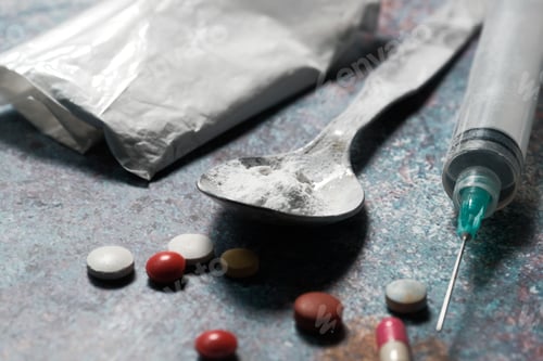 Preview: drug addiction concept with heroine packet and syringe on black backgrund