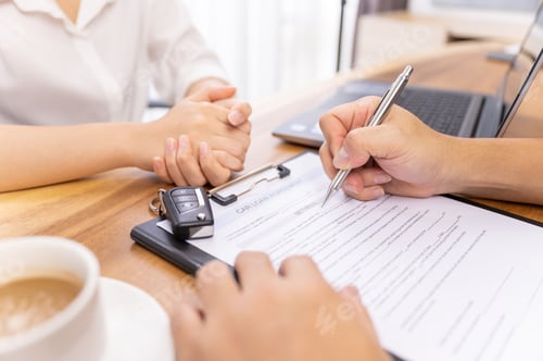 Preview: Woman's hand signing a car loan contract agreement