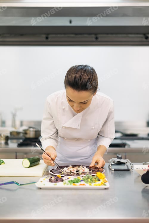 Preview: Pretty professional chef cooking in a kitchen.