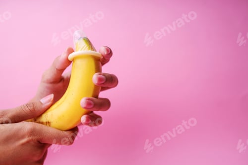 Preview: Man's Hands Holding Banana With Elastic Condom