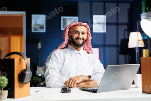 Preview: Smiling Arab man using modern technology