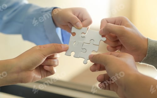 Preview: Group of businessmen holding white jigsaw puzzle pieces.