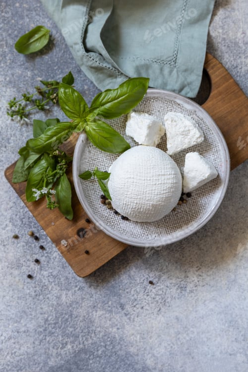 Preview: Homemade whey ricotta cheese or cottage cheese with basil ready to eat.