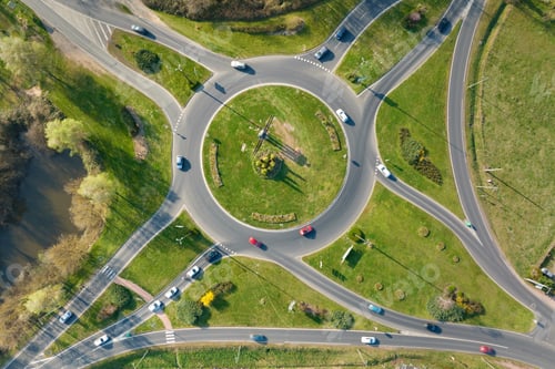Preview: Aerial view of road roundabout intersection with moving heavy traffic.