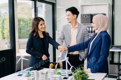 Preview: Group of diverse multiethnic businesspeople standing neare table looking at model