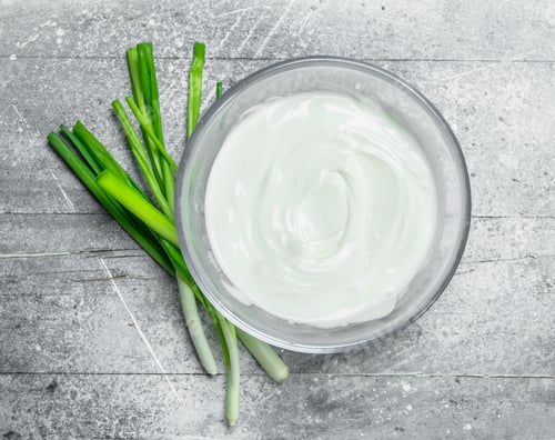 Preview: Sour cream in bowl with green onions.