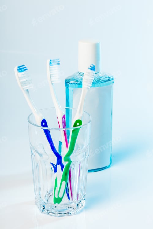 Preview: Toothbrushes in glass on table on light background