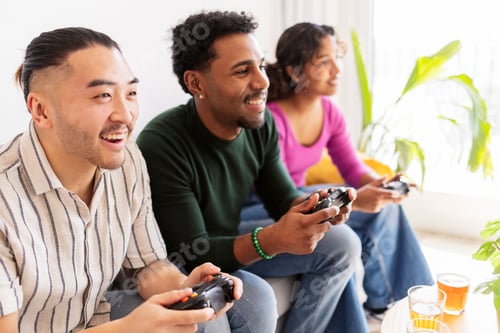 Preview: Friends enjoying video game console playing together at home