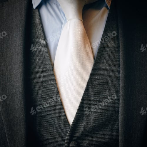 Preview: Close-up of a man wearing a cream tie and black suit