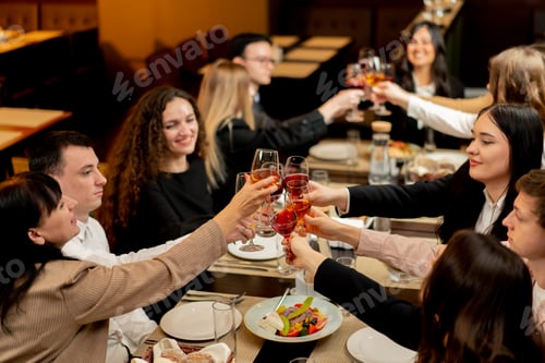 Preview: work colleagues in a restaurant celebrating the conclusion of a new deal toast with glasses of wine