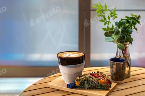 Preview: A cup of coffee with a piece of veggie pie on a table