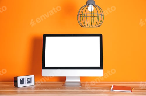 Preview: Modern computer monitor on table against color wall. Mock up with space for text