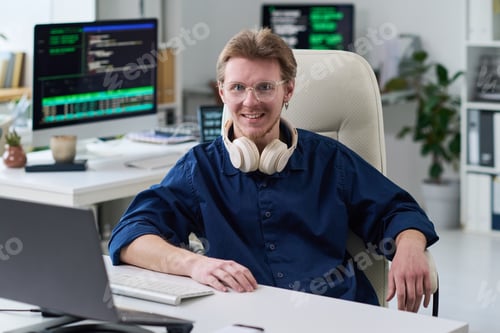 Preview: Portrait of Young Man Smiling While Working in Office