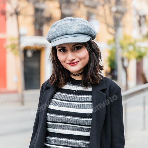 Preview: Smiling ethnic lady looking at camera on street in autumn