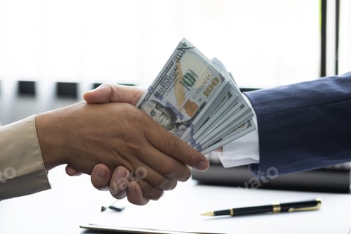 Preview: Close-up businesspeople shaking hands and giving bribes or wages.