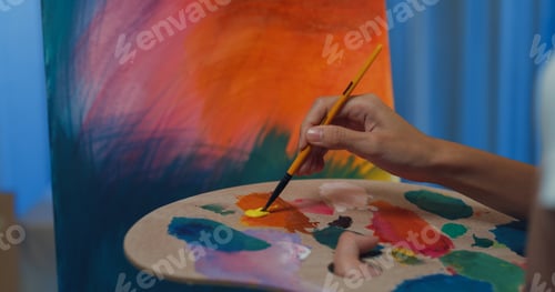 Preview: Lady wear apron holding palette use brush painting on canvas create artwork.