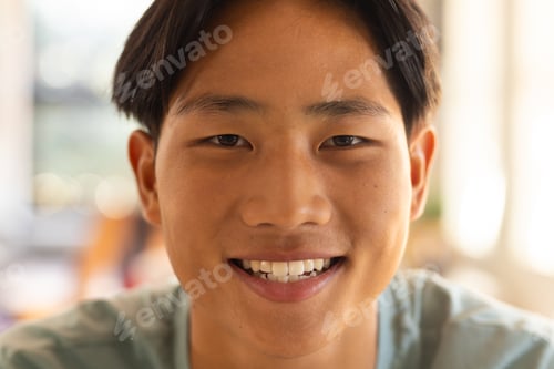 Preview: Smiling teenage boy in high school, looking at camera with bright expression