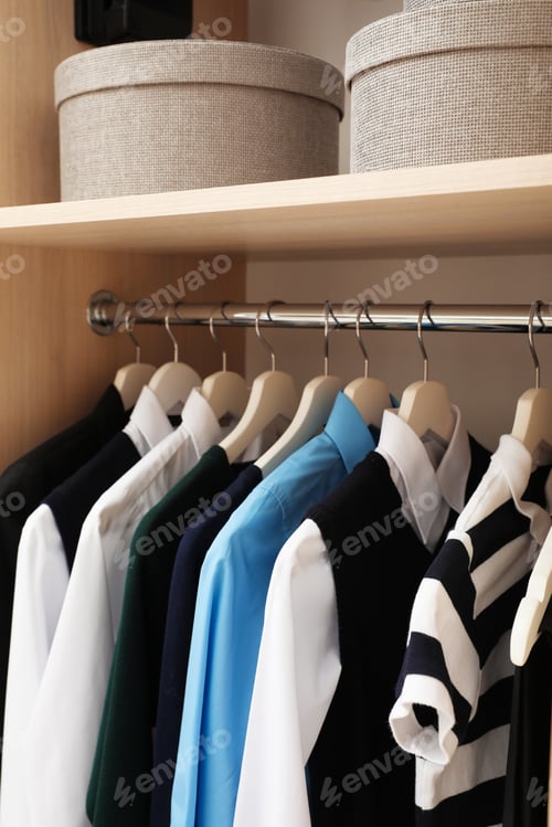 Preview: Hangers with teenage clothes on rack in wardrobe, closeup