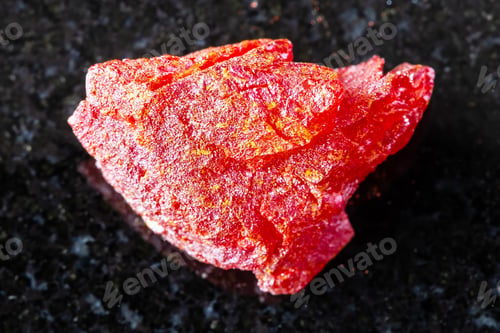Preview: sample of raw realgar mineral on black granite