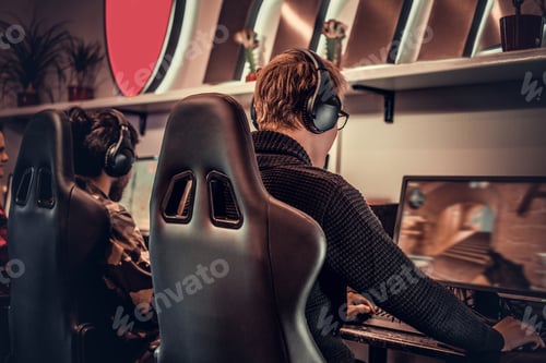 Preview: Team of teenage gamers plays in a multiplayer video game on pc in a gaming club.