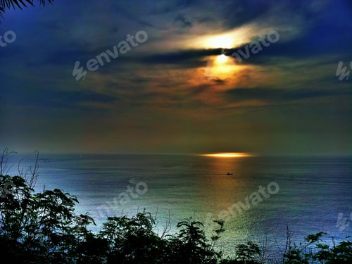 Preview: Silhouette of tree in frame with beautiful ocean sunset seascape blur background