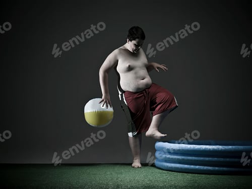 Preview: Young boy preparing to jump into an inflatable pool with a beach ball at his side