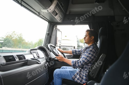 Preview: A young Indian male truck driver sits behind the wheel