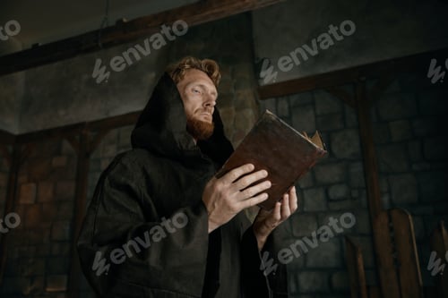 Preview: Thoughtful medieval monk reading ancient book in cathedral