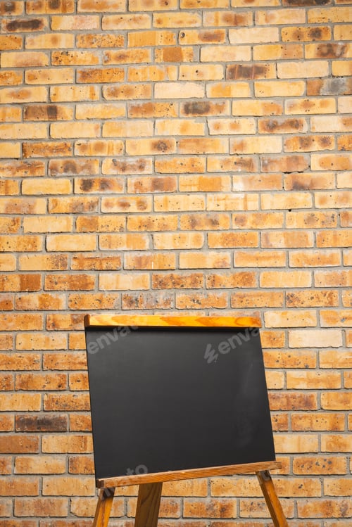 Preview: Black sign in wooden frame and copy space on brick wall background