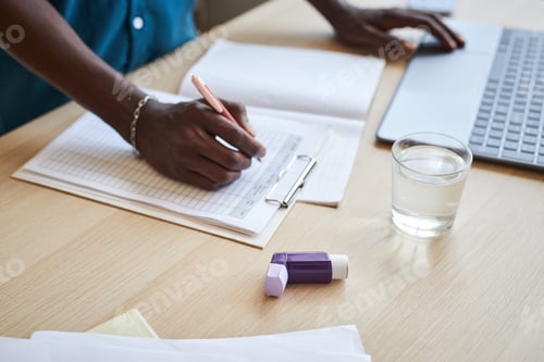 Preview: Close up of person with chronic illness working in office at desk asthma inhaler