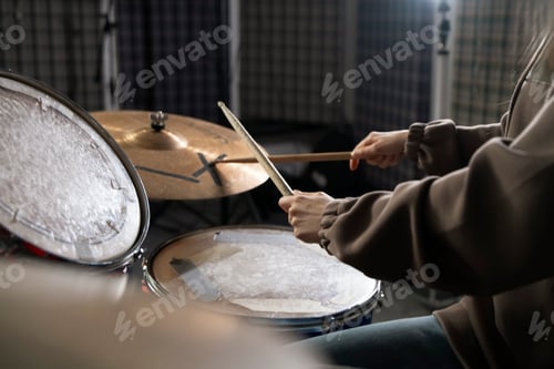 Preview: a Drummers Hands Holding Sticks Mid-Performance on a Drum Set