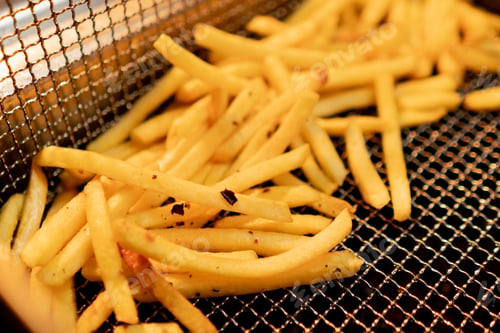 Preview: kitchen in the hotel restaurant, delicious freshly prepared French fries lie in the fryer close-up