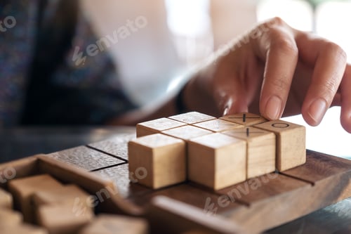 Preview: Closeup image of people playing wooden Tic Tac Toe game or OX game