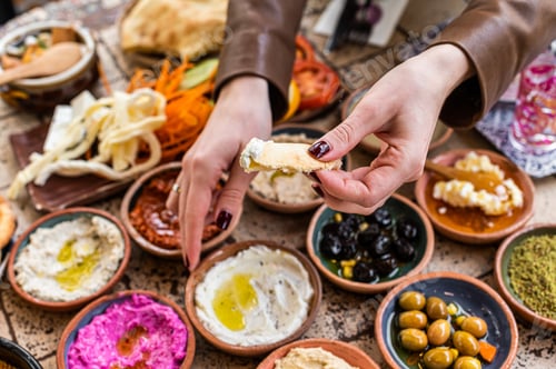 Preview: Women eating Traditional Turkish Village Breakfast served in restaurant. Top view