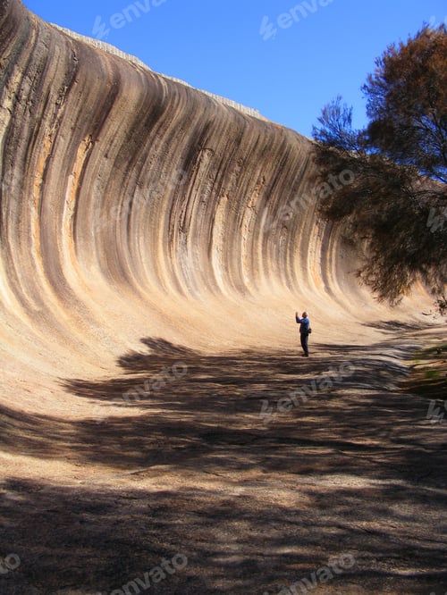 Preview: Man taking a photo at Wave Rock, a famous tourist attraction in Hyden, Western Australia.