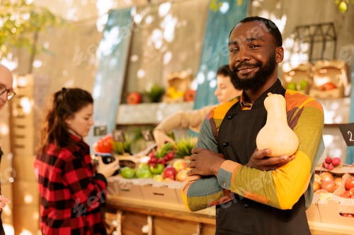 Preview: Black man holds squash at marketplace