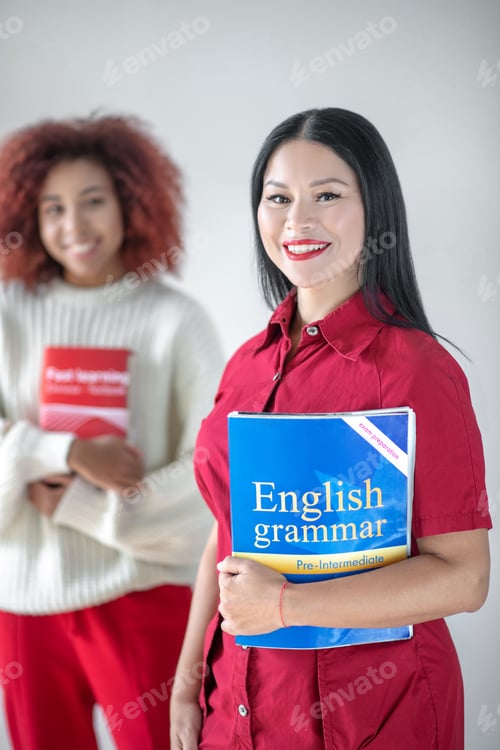 Preview: Asian dark-haired woman holding English grammar book