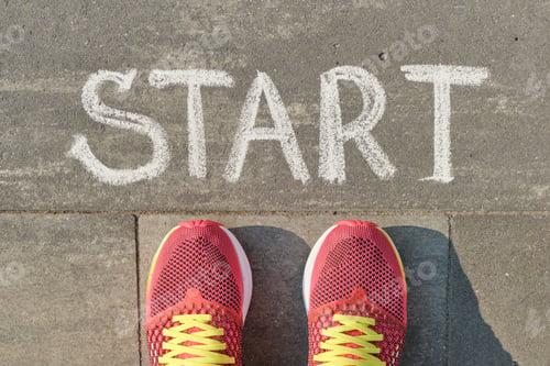 Preview: Word start written on gray pavement with woman legs in sneakers, view from above