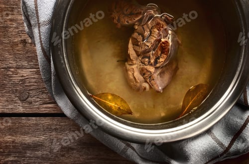 Preview: Meat broth from beef in a metal pan on the wooden table