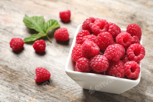 Preview: Bowl with ripe aromatic raspberries on wooden table