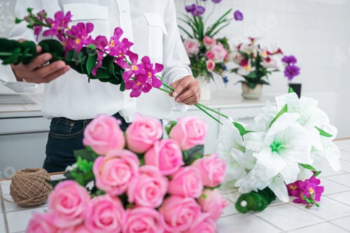 Preview: Arranging artificial flowers decoration at home, Young woman flo