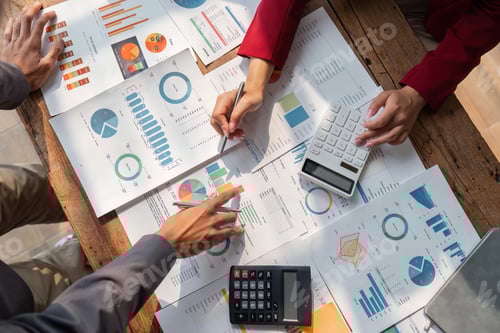 Preview: Business people brainstorming at office desk analyzing financial reports and pointing out financial
