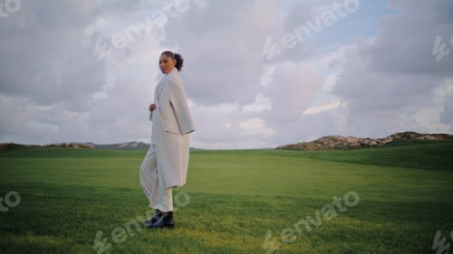 Preview: Calm woman walking field on spring vacation. Beautiful serene model look camera