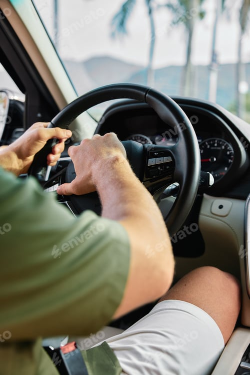 Preview: Man driving a car with hands on the steering wheel, dashboard visible in the background