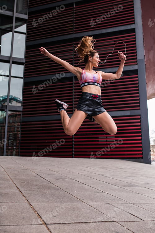 Preview: Cheerful happy sportswoman jumping up