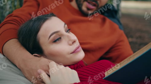 Preview: Tender woman relaxing picnic lying on man chest close up. Man reading book aloud