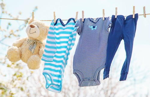Preview: Baby clothes and accessories weigh on the rope after washing in the open air. Selective focus.