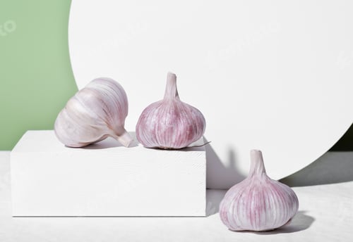 Preview: The whole unpeeled garlic on white geometric podium or pedestal. raw garlic