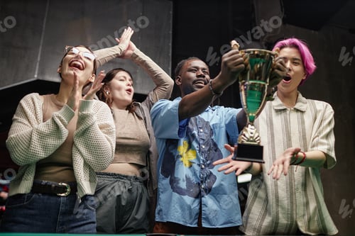 Preview: Celebrating Victory Holding Trophy in Cozy Indoor Setting