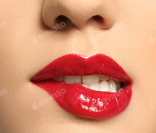 Preview: Beautiful young woman with bright makeup biting lip on white background, closeup